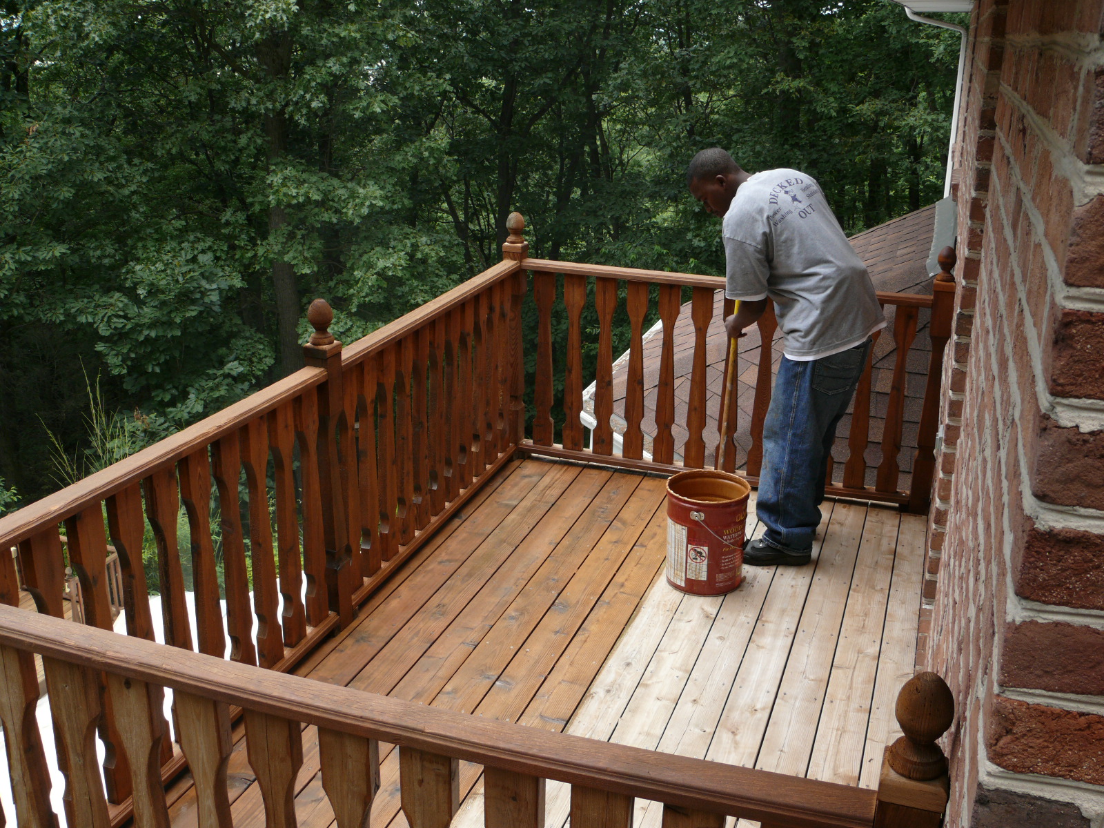 Deck staining by hand using a brush.