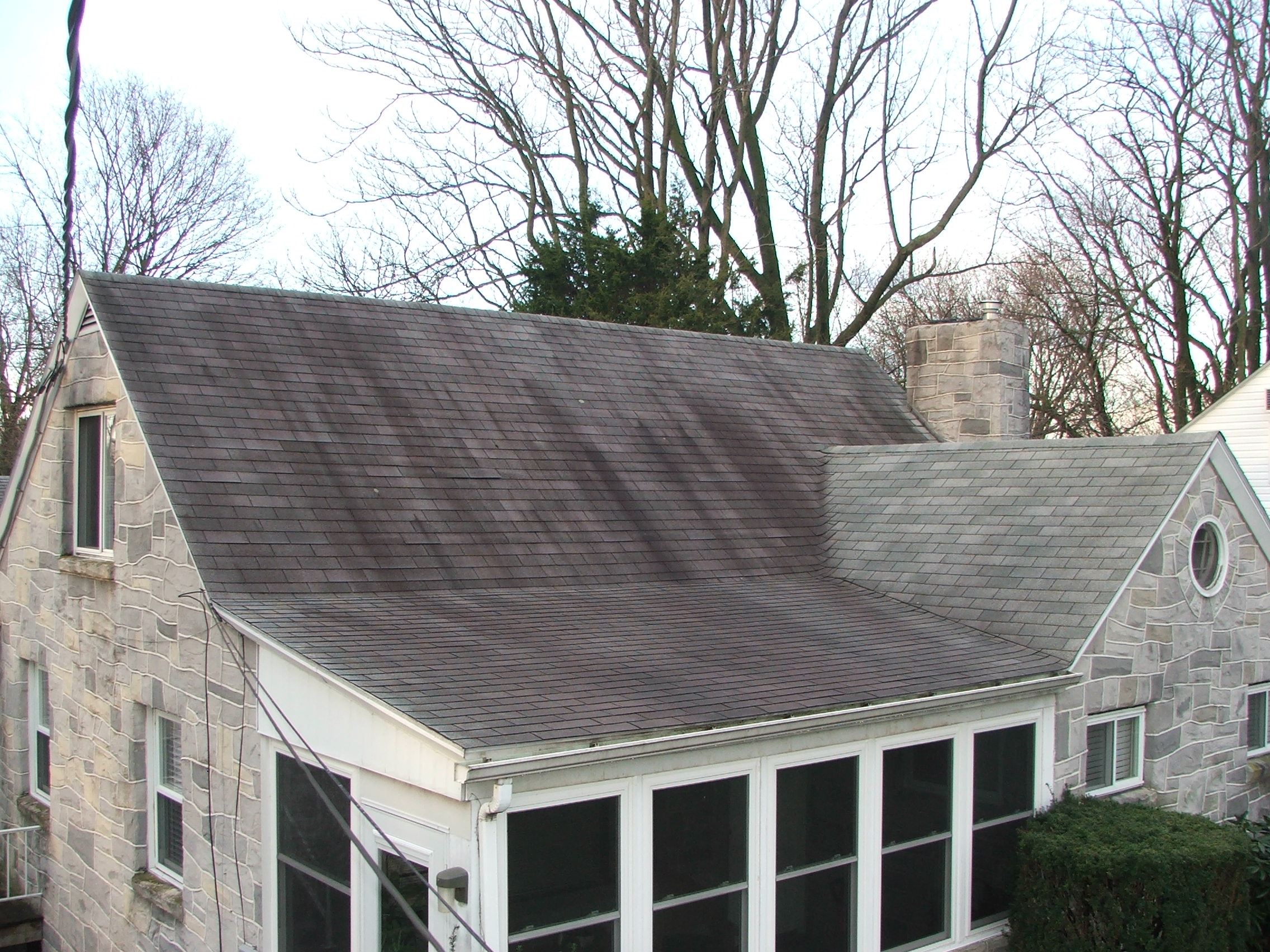 Dirty black stains on house roof before pressure washing