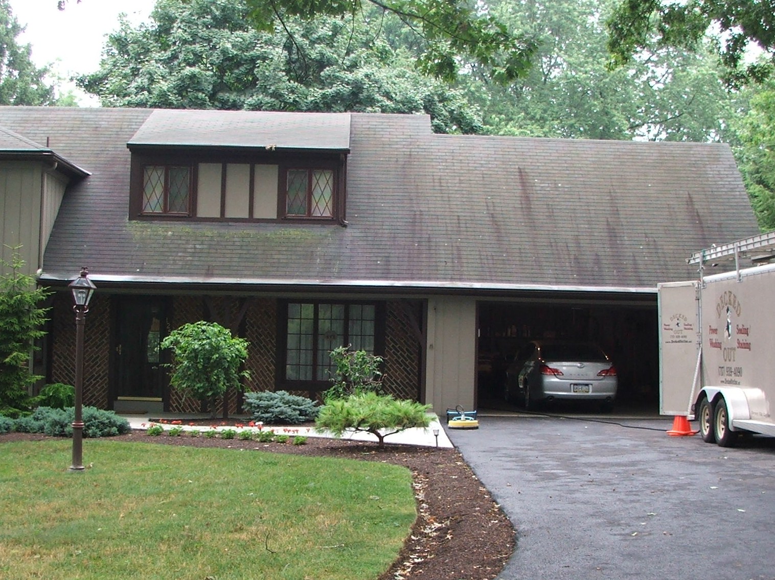 Dirty black streaked mildew stain and green-algae coveres the aslphalt shingles.